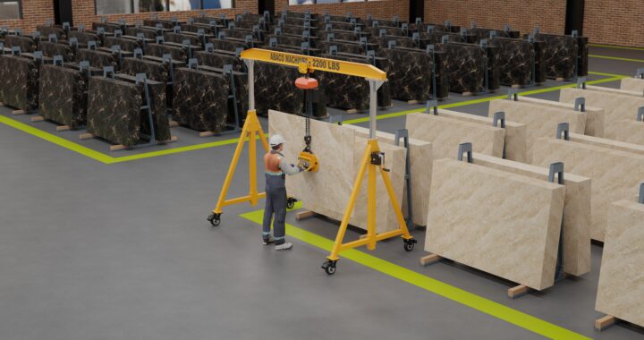 Crane and vacuum lifter handling a large stone slab during unloading and material handling operations.